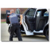 officer standing outside his police cruiser holding a pro guard viper shield while reaching for his gun